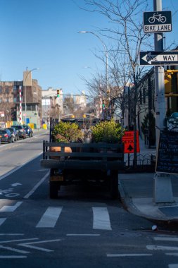 Brooklyn, ABD 'de sokakta yemyeşil bitkilerle dolu bir minibüsün dikey görüntüsü.