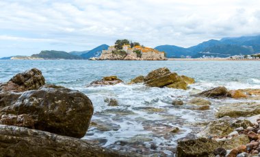 Adriyatik Denizi üzerindeki bulutlu mavi gökyüzü ve Karadağ 'ın Budva kentinde Sveti Stefan