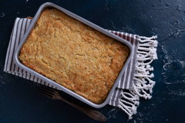 Tavada karnabahar güveci, çatal ve masa örtüsü.