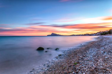 Deniz kıyısında gün batımının güzel bir görüntüsü.