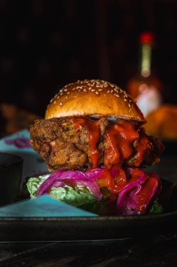 Lezzetli ve soslu bir burgerin dikey çekimi.