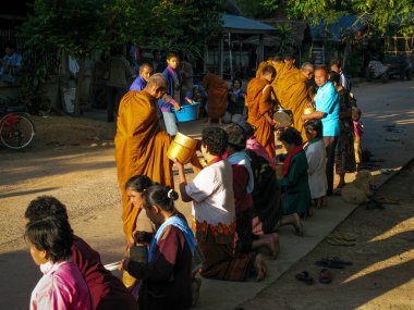 İnsanlar, Songkran festivalinde Tayland 'da dua etmek için yaşlıların ellerine su döküyor.