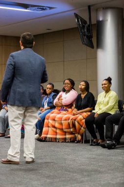 Eğitimcinin, çeşitli yetişkin öğrencileri kişisel finansman konusunda eğittiği dikey bir yakın çekim. Johannesburg, Güney Afrika.