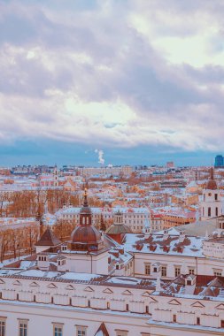 Litvanya, Vilnius 'un kışın karlı çatıları olan binalarının dikey görüntüsü.