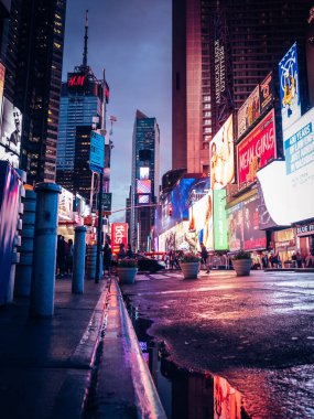 New York 'taki gece hayatının dikey görüntüsü - Reklam panoları ve turistlerle dolu Time Square