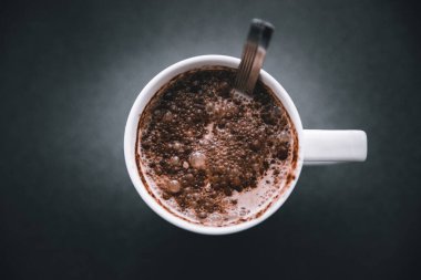 Koyu renkli kakao tozlu bir fincan sıcak çikolata.