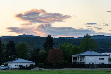 Gün batımında ormanda kır evleri olan güzel bir kırsal alan.