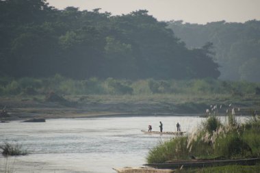 Nehiri geçen sığınak kanosundaki insanlar. Nepal, Chitwan.