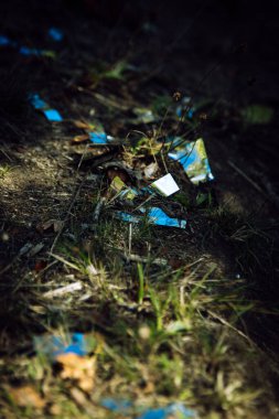 Çimlerin üzerindeki gümüş folyonun dikey yakın çekimi.