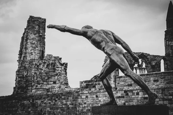 Eine Graustufenaufnahme Der Statue Des Whitby Gladiators Mit Den Ruinen — Stockfoto