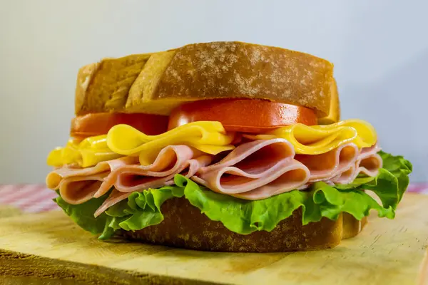 Primer Plano Delicioso Sándwich Jugoso Jamón Queso Tomate Una Tabla —  Fotos de Stock
