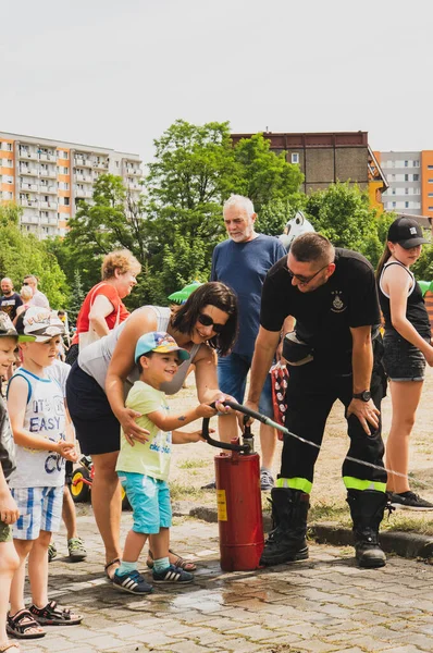 Stare Zegrze地区の消防署のイベント中に子供と消防士が水で撃つ — ストック写真