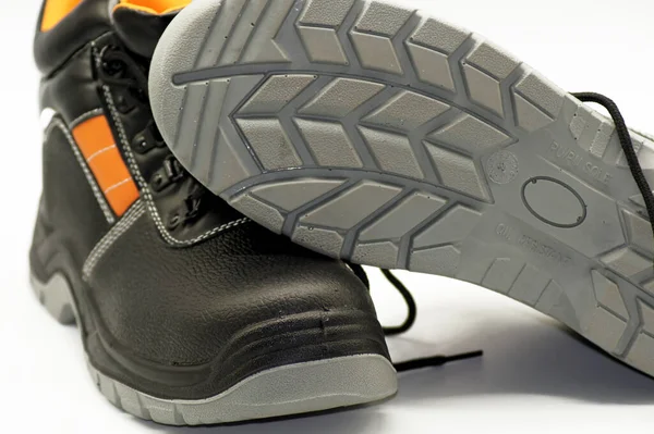 A closeup of a black flipped Safety shoes isolated on a white  background