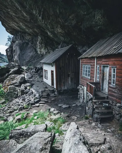 Vertikale Aufnahme Von Zwei Kleinen Häusern Unter Bergfelsen — Stockfoto