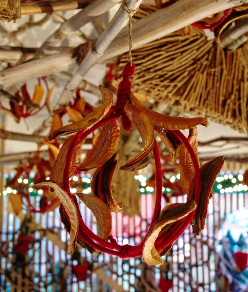 A vertical shot of a hanging ornate in a ball shape with dry leaves