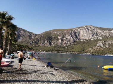 Gölün kıyısında, kayalık dağların arasında güneşli bir gün