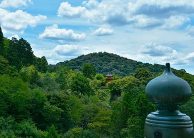 Japonya 'daki dağların ve ormanların arasındaki Kyoto türbesinin fotoğrafı.