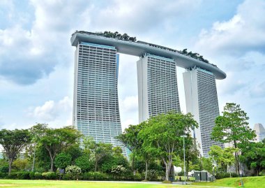 Singapur 'daki ünlü Marina Körfezi Oteli' nin alçak açılı görüntüsü. Bulutlu bir gökyüzünün altında.