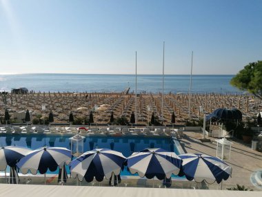 Jesolo, İtalya 'da kumsaldaki şemsiyeler ve güneşlikler.