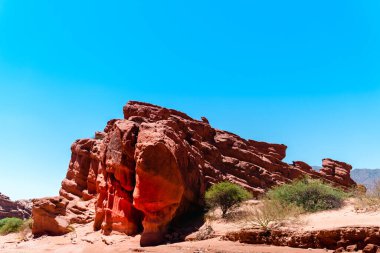Bulutlu gökyüzüne karşı kızıl kaya dağlarının büyüleyici görüntüsü