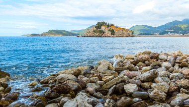 Adriyatik Denizi üzerindeki bulutlu mavi gökyüzü ve Karadağ 'ın Budva kentinde Sveti Stefan