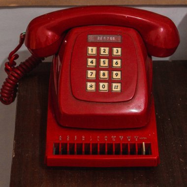 Eski bir kırmızı telefonun yakın plan görüntüsü.