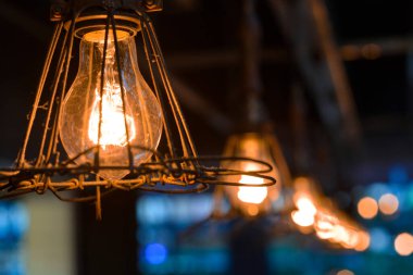 Çatıya asılmış eski bir el fenerinin seçici bir resmi.