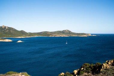 Sardunya 'daki yeşil tepelerle çevrili deniz manzarası.