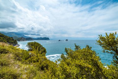 Adriyatik Denizi üzerindeki bulutlu mavi gökyüzü ve Karadağ 'ın Budva kentinde Sveti Stefan