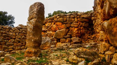 Kırsal bölgedeki kayalardan yapılmış eski bir yapının manzarası.
