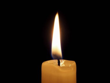 Karanlıkta yanan bir mumun yakın çekim görüntüsü.