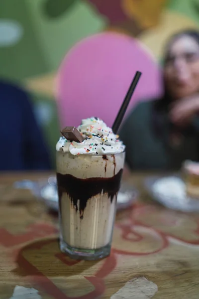 Tiro Close Xícara Milkshake Com Uma Palha Preta Mesa Com — Fotografia de Stock