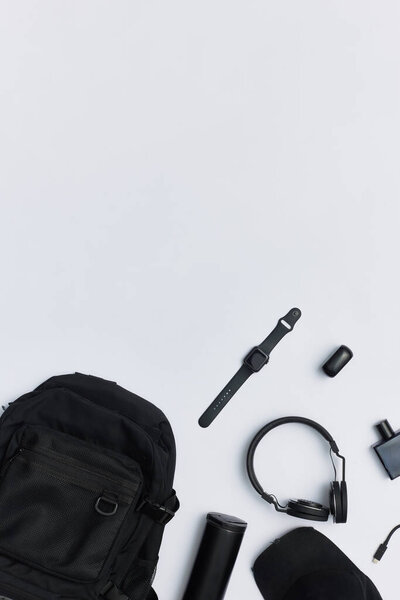 Верхний вид черного рюкзака и его содержимое изолированы на белом фоне с копировальным пространством