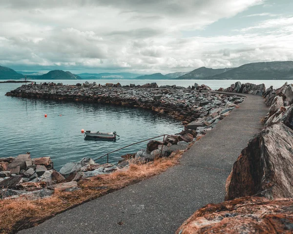 山や丘に囲まれた大きな湖に入る石造りの桟橋のショット — ストック写真