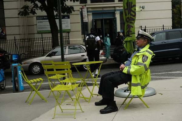 Sandalyede Oturan Neon Renkli Sarı Ceketli Bir Polis — Stok fotoğraf