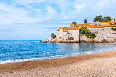 Adriyatik Denizi üzerindeki bulutlu mavi gökyüzü ve Karadağ 'ın Budva kentinde Sveti Stefan