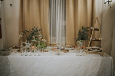 Düğün salonunun dekorasyonuyla birlikte yemek masasının bir fotoğrafı.