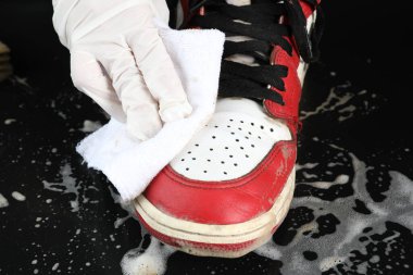 Kızıl bir Nike hava kuvvetleri bir fırça tarafından sabunla ovuluyor.