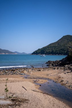 Clearwater Körfezi plajının güzel bir manzarası, Hong Kong 'da güneşli bir gökyüzüne karşı yeşil tepeler.