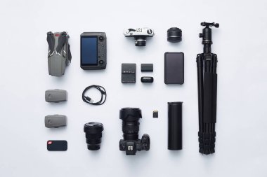 Beyaz zemin üzerinde temel fotoğraf ekipmanlarının düz bir uzantısı