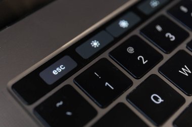 MacBook Pro dizüstü bilgisayarının dokunmatik çubuğunda Escape tuşunun yakın plan görüntüsü.