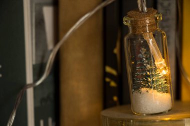 Küçük cam bir kavanozda Noel 'in parlak dekoratif ışıklarının yakın çekimi.