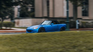 Blue Car 'ın Boston siluetinin önünde hızla giderken görüntüsü.