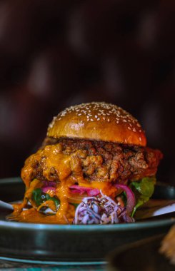 Lezzetli ve soslu bir burgerin dikey çekimi.