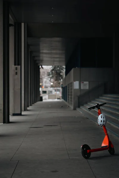 Eine Vertikale Aufnahme Eines Orangefarbenen Motorrollers Und Helms Der Einem — Stockfoto