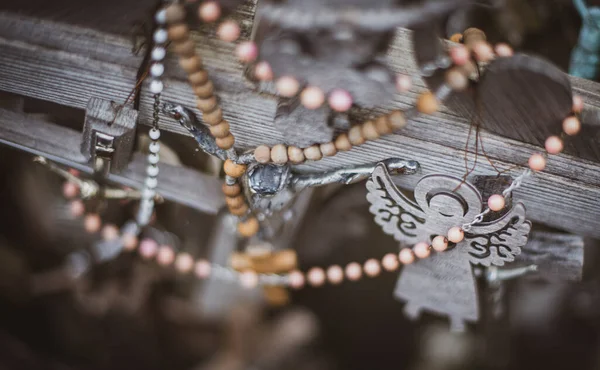 环绕着木制十字架的项链和天使饰物的特写镜头 — 图库照片