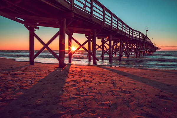 大きな木製の橋の上のビーチで夕日の美しい景色 — ストック写真