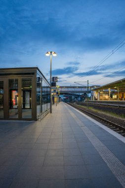 Almanya 'daki bir tren istasyonunun mavi gökyüzü arka planındaki dikey görüntüsü.