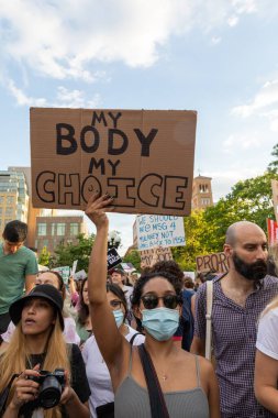 Protestocular, Anayasa Mahkemesi 'nin ABD' nin NYC eyaletindeki Washington Square Park 'ta Roe V. Wade' i devirmesinin ardından vücut özgürlüğüyle ilgili mukavva tabelalar tutuyorlar.