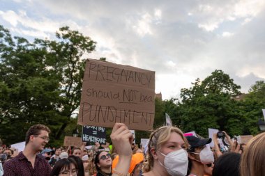 Protestocular, Anayasa Mahkemesi 'nin ABD' nin NYC eyaletindeki Washington Square Park 'ta Roe V. Wade' i devirmesinin ardından vücut özgürlüğüyle ilgili mukavva tabelalar tutuyorlar.